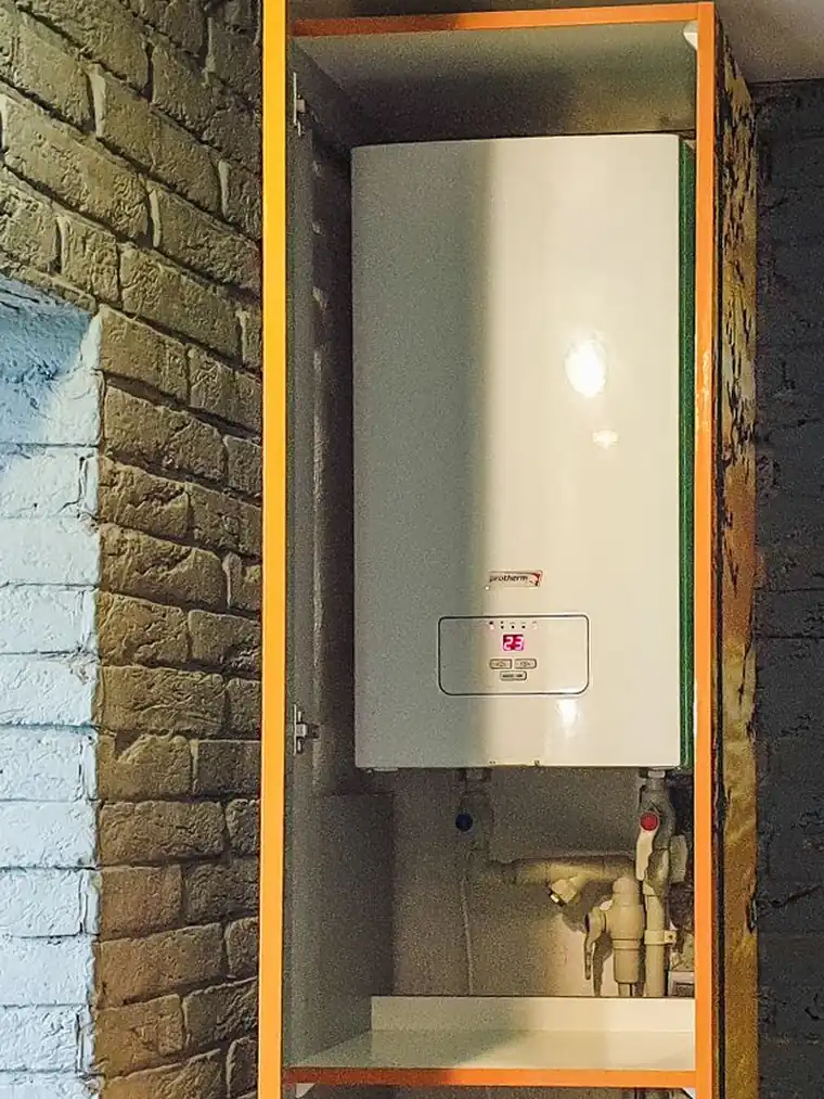 A modern wall-mounted tankless water heater, installed and piped in
