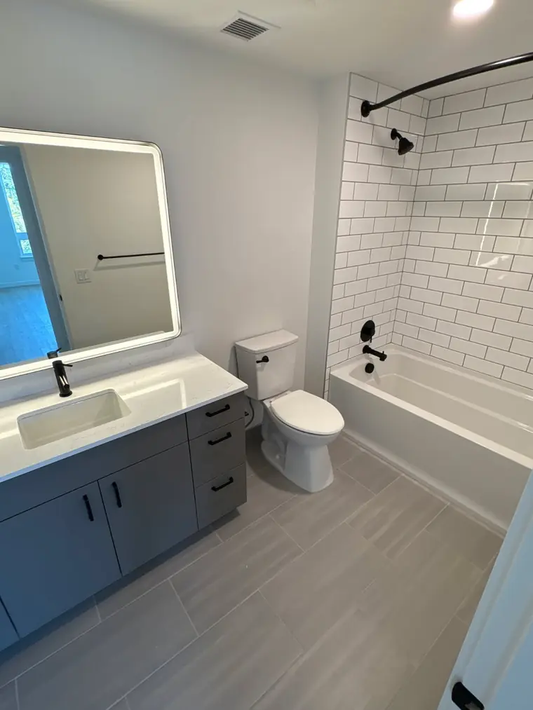 Bathroom remodel completed on Camano Island — subway-tile tub surround, quartz vanity, matte black fixtures
