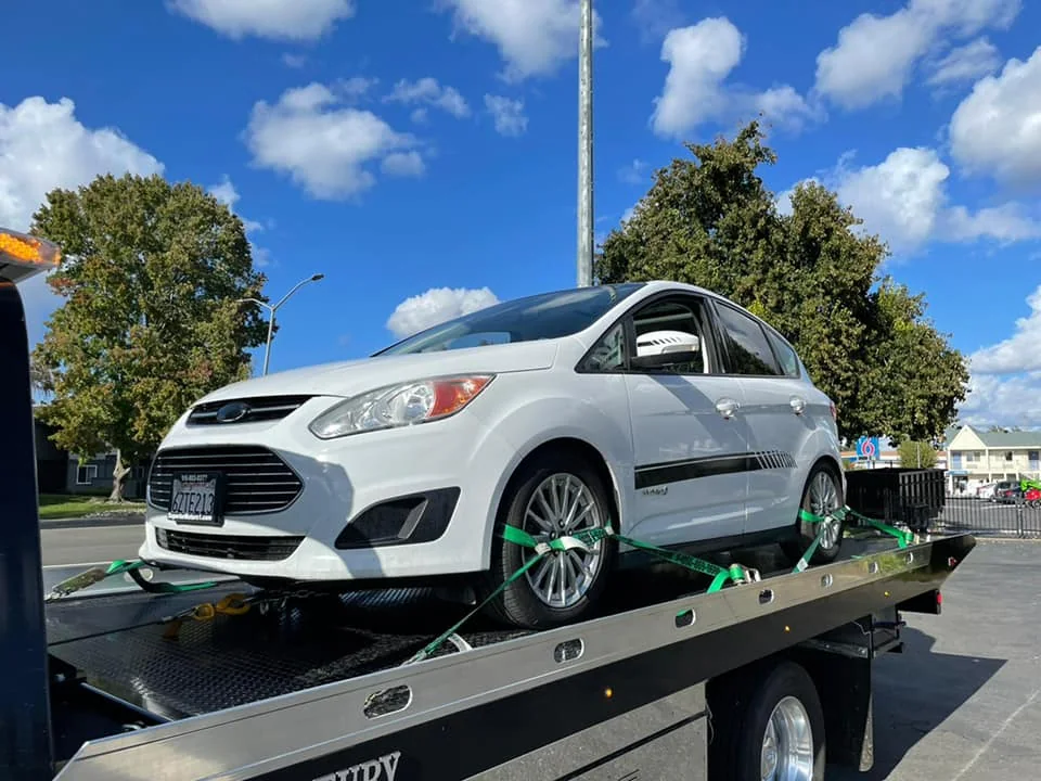 White car secured on Tiger Towing’s flatbed truck