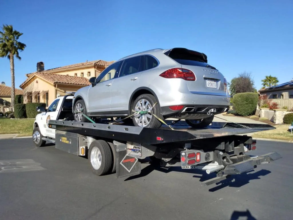 White sports coupe secured for flatbed transport