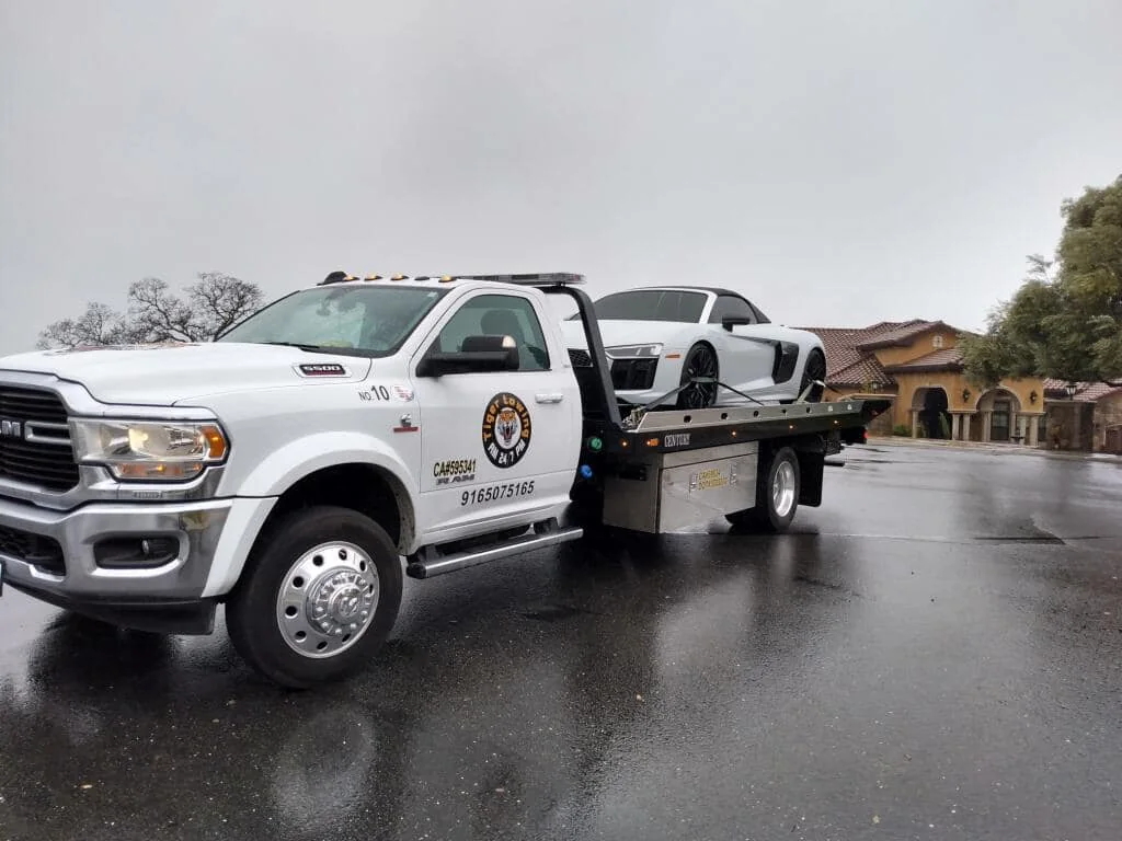 Tiger flatbed carrying a white Audi R8