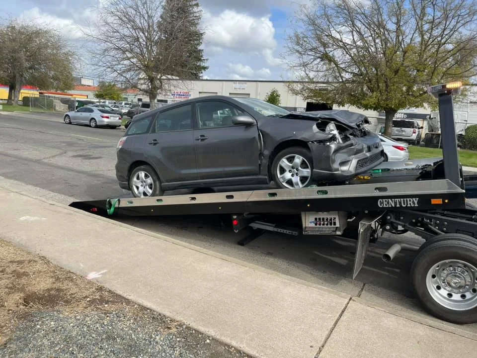 Damaged gray vehicle secured on Tiger Towing’s truck