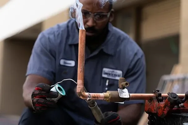 Professional plumber working carefully on copper pipes