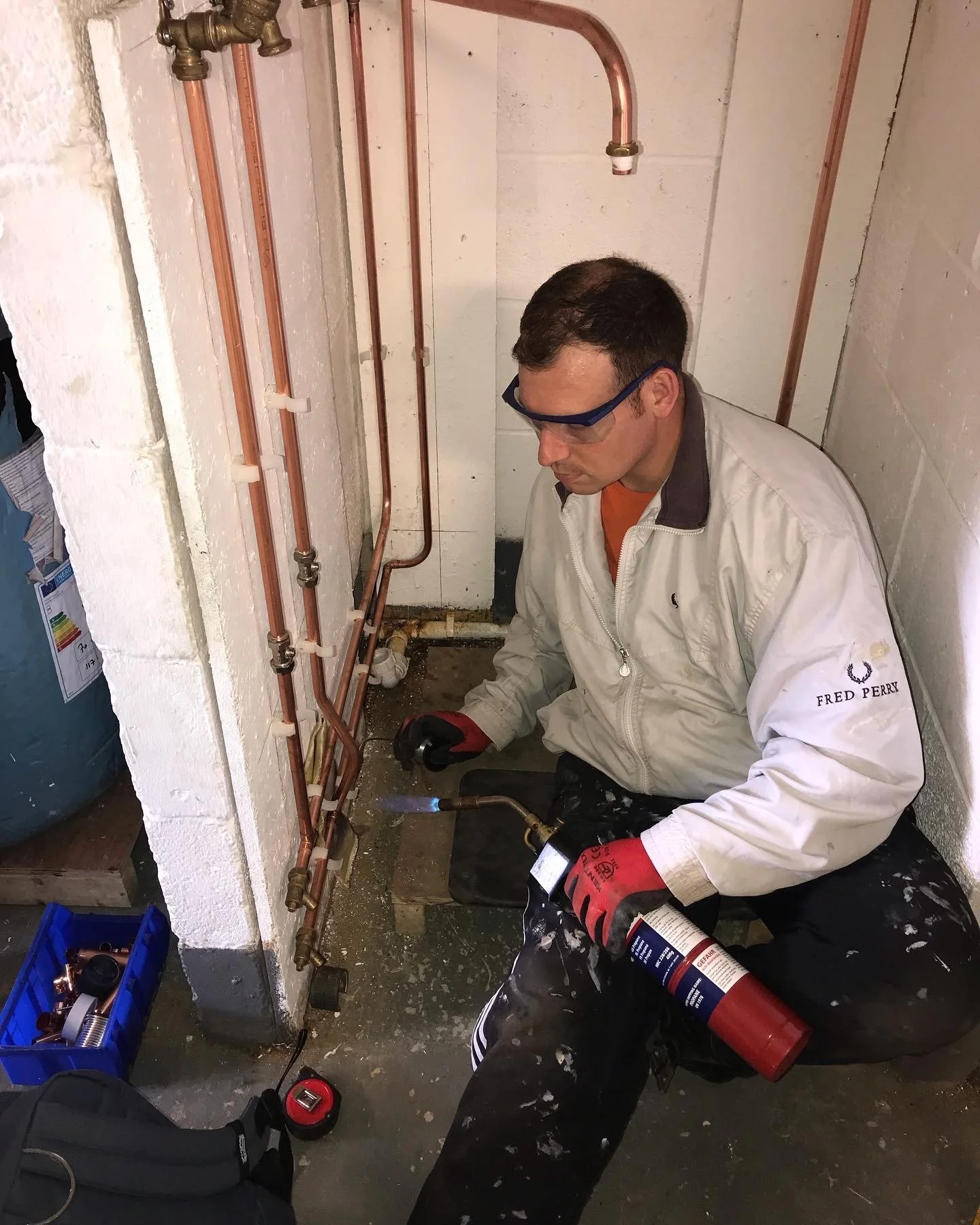 Professional plumber working beneath a kitchen sink